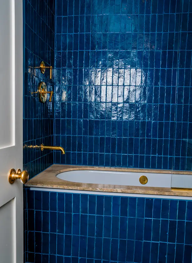 Victorian house renovation in Notting Hill with deep blue bathroom tiles and brass fittings.