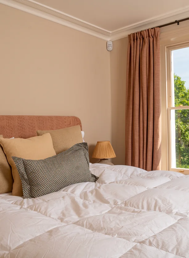 Renovated Victorian house in Notting Hill with terracotta headboard and natural light.