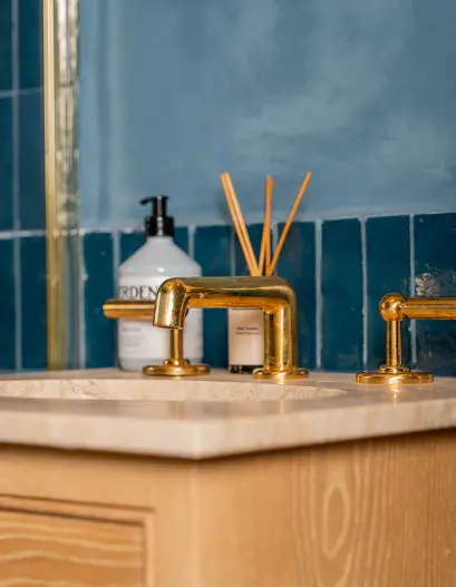 Luxury bathroom renovation in London by trusted builders, featuring bespoke brass fittings and high-end finishes.