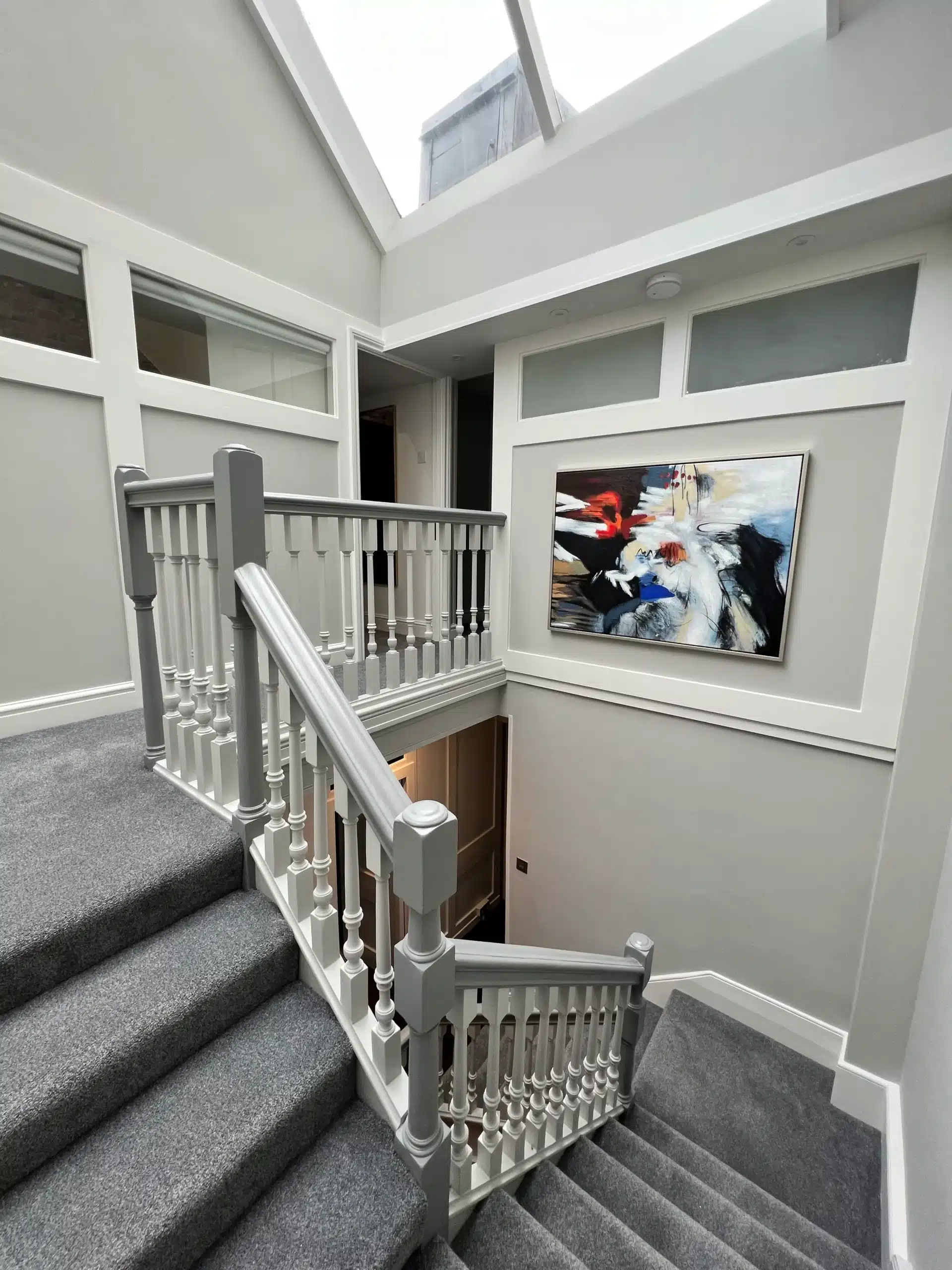 Builders London creating a modern loft conversion with skylight and grey staircase design.