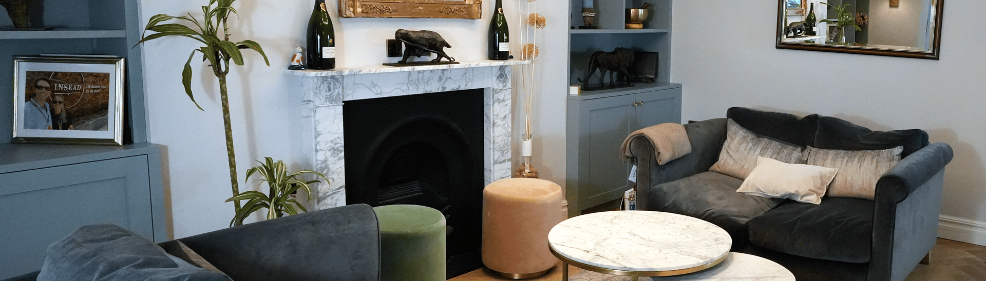 Loft conversion London with marble fireplace and velvet sofas in elegant living room.