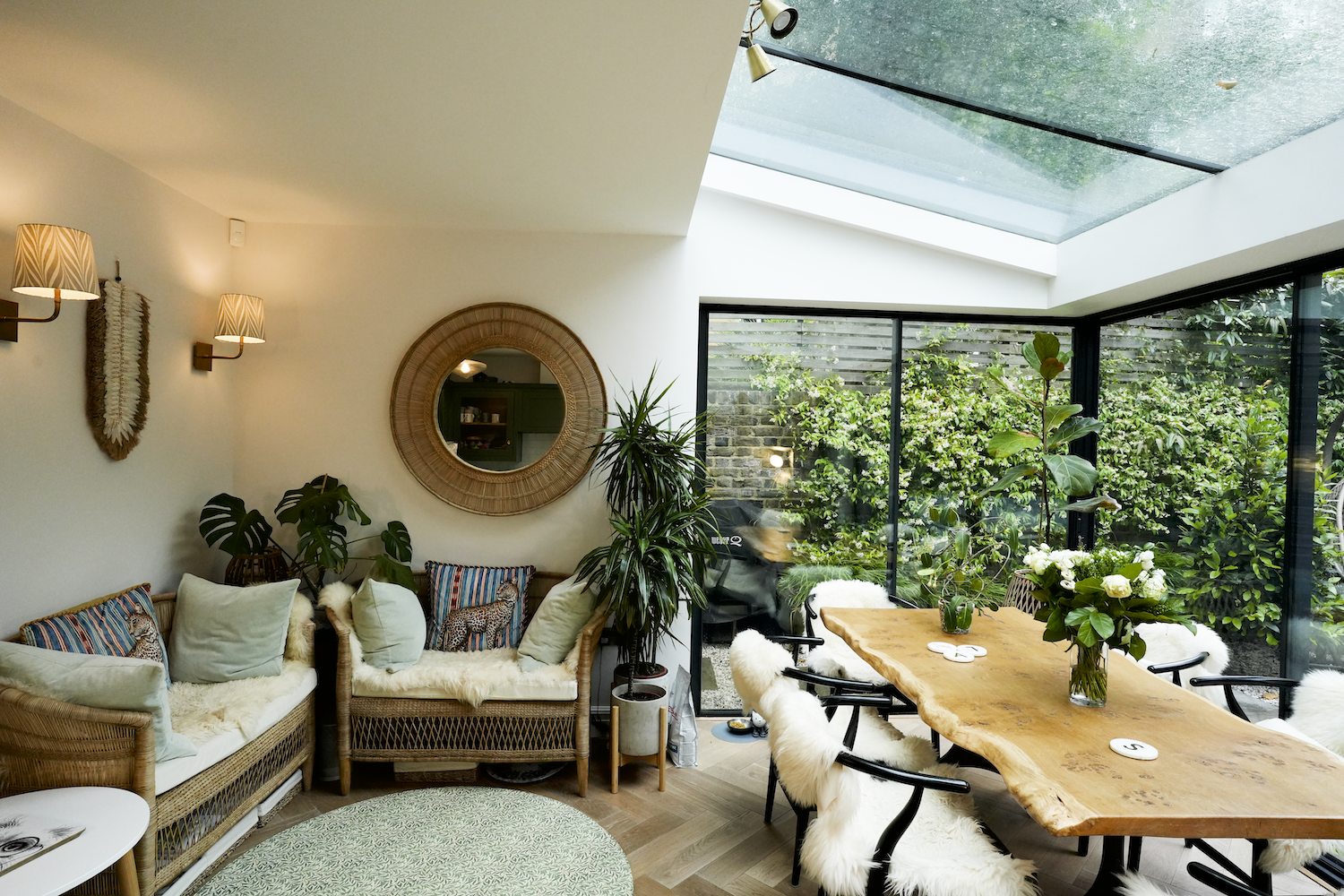 Home renovation London rear extension with dining area, large rooflight and black sliding doors opening to the garden