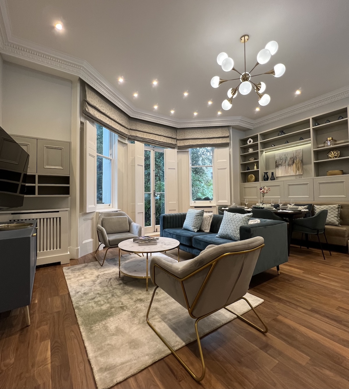 Period property renovation London open-plan reception room with restored cornicing, bay window and fitted joinery