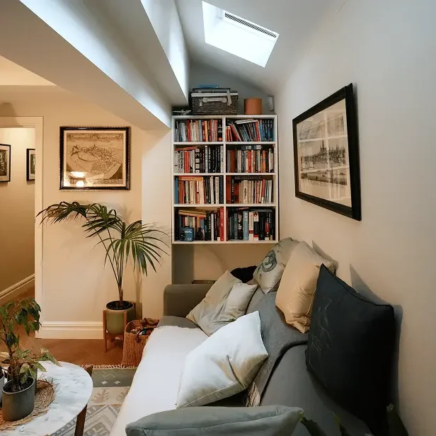 Basement conversion Chelsea with sofa, skylight, and bespoke bookshelves.