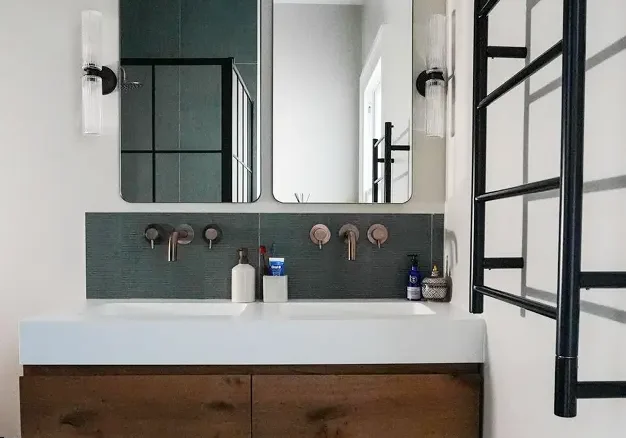Bathroom renovation London with double sink vanity, mirrors, and wall lighting.