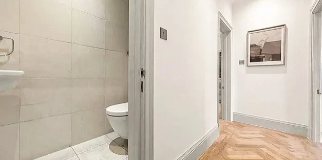 Bathroom renovation London with WC off hallway and herringbone wood flooring.
