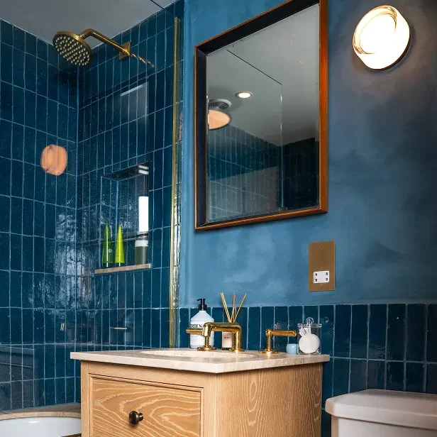 Bathroom renovation London in Notting Hill with bespoke vanity, marble basin, and blue tiles.