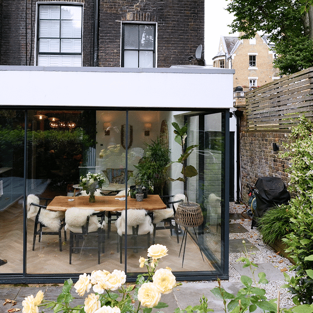Builders in Chelsea delivering modern glass extension with aluminium framing and oak flooring.