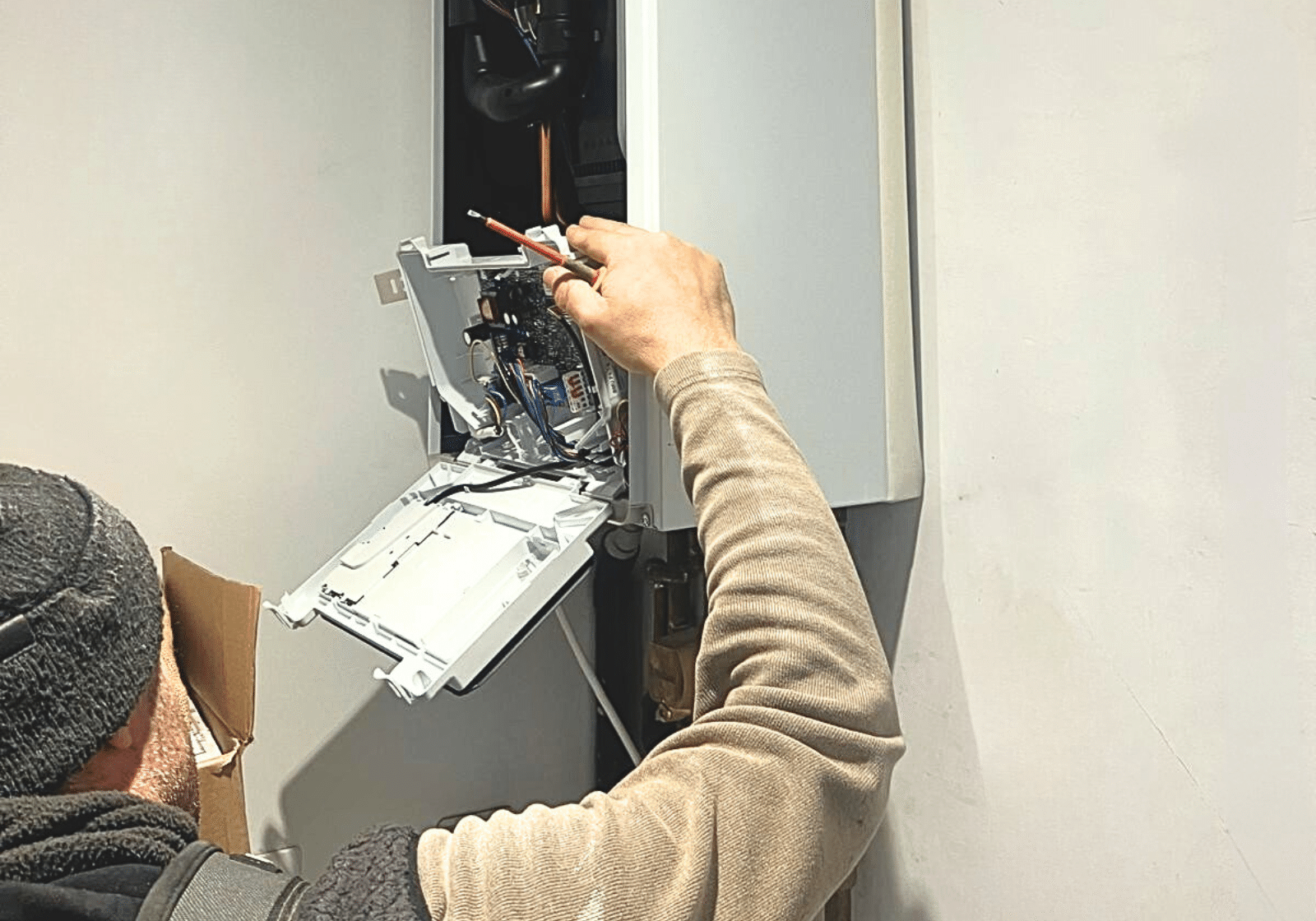 Builders in Chelsea installing boiler system with precision as part of a home renovation.