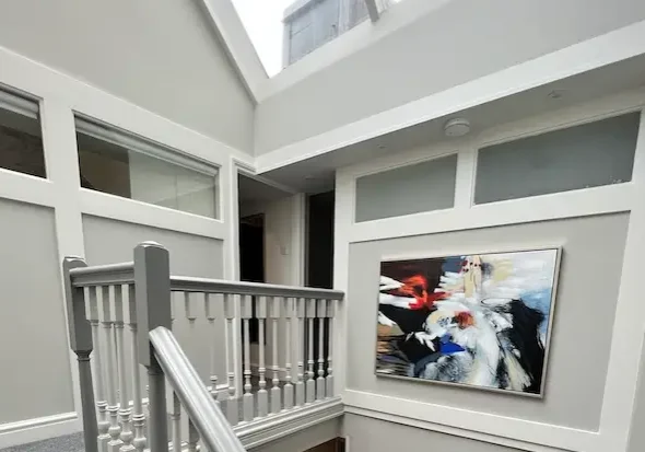 Builders in Kensington completing a bespoke loft conversion with skylight and grey staircase detailing