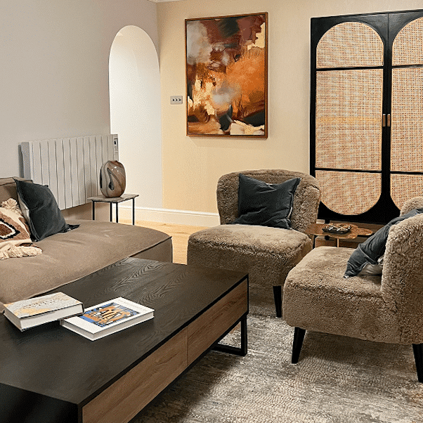 Finished living room in a Notting Hill home renovation, with layered seating, artwork and an arched doorway.