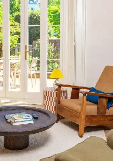 Finished sitting room after a home renovation, with French doors opening onto the garden.