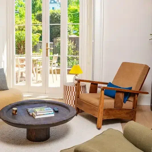 Light-filled living room in a renovated Notting Hill home with French doors opening to the garden.