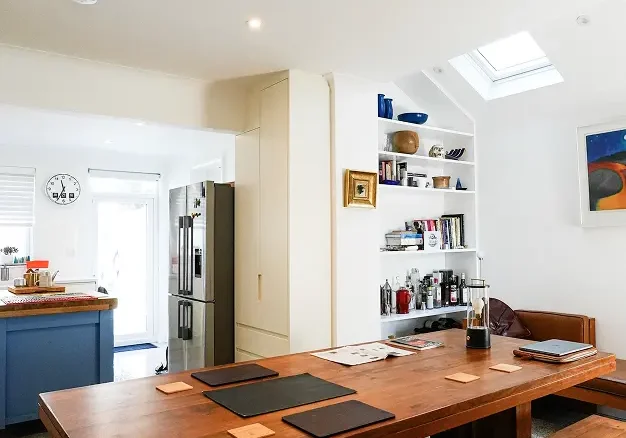 Kitchen renovation London with blue island, double fridge, and contemporary finishes.