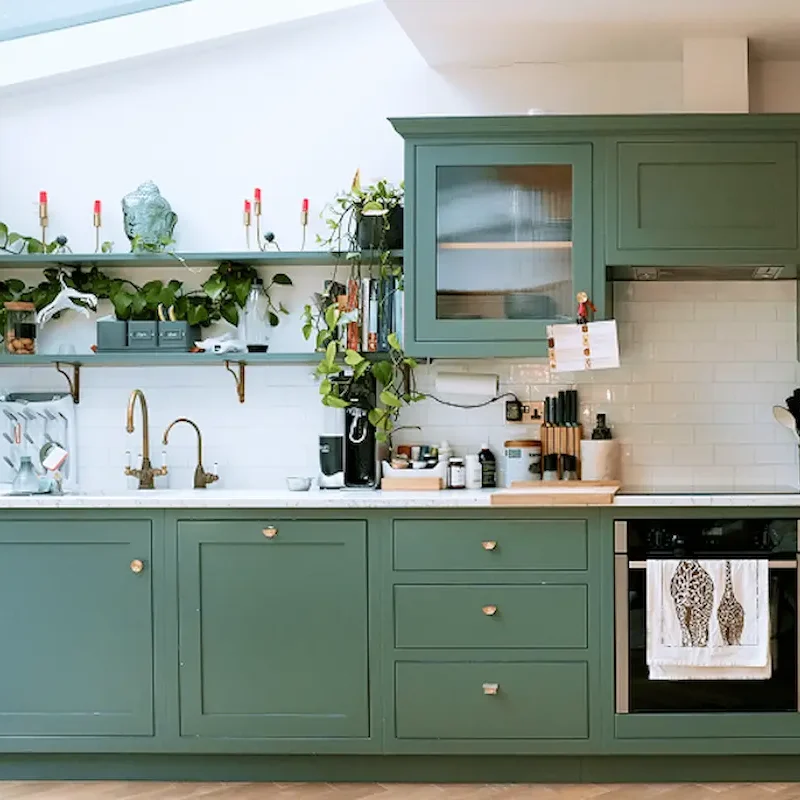 Green cabinet kitchen with marble worktops and modern appliances in Chelsea kitchen renovation London.