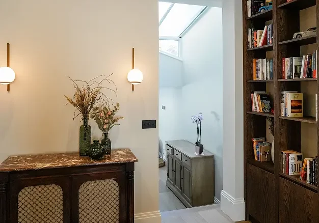 Refurbished London reading nook with bespoke shelving and custom lighting.