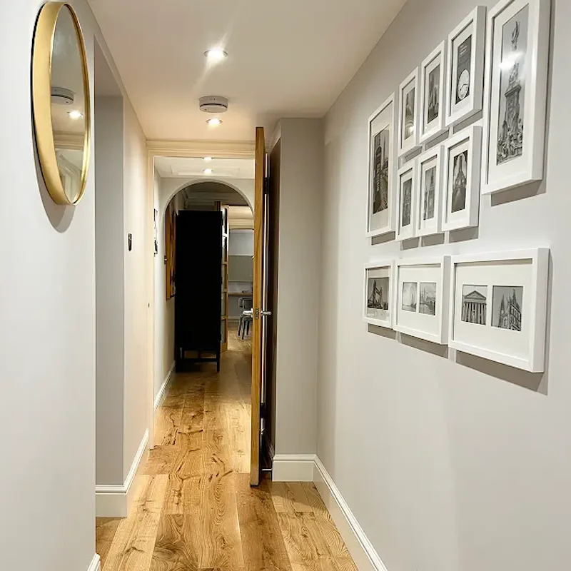 Property maintenance London with refreshed hallway, framed artwork, and wooden flooring.